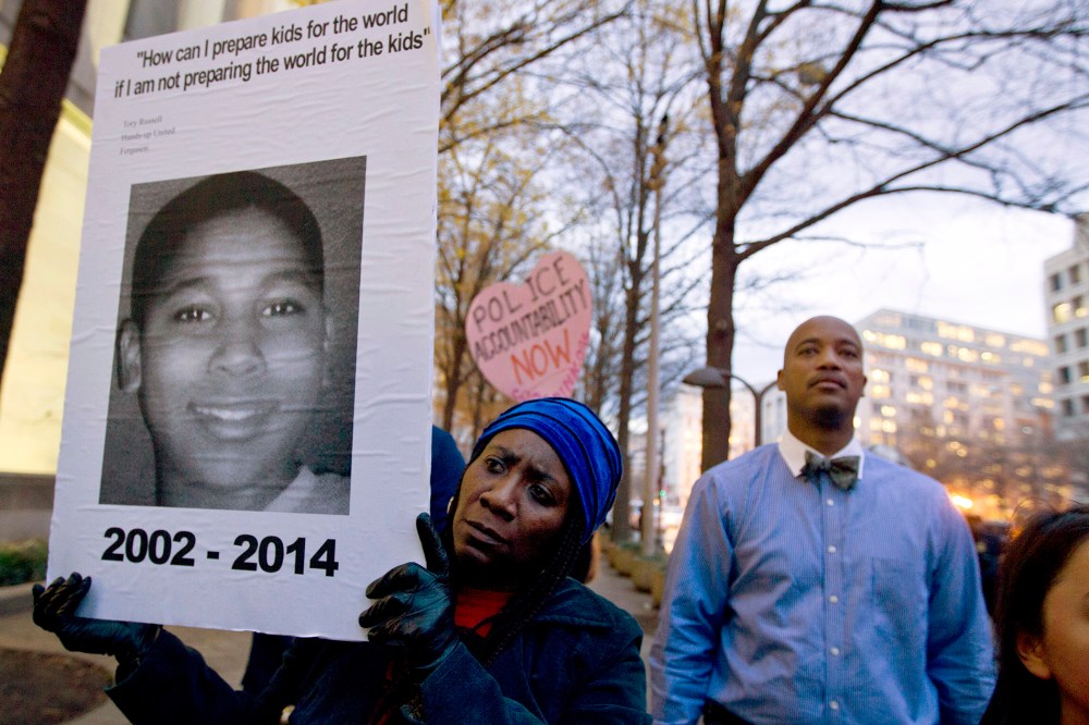 In a Monday, Dec. 1, 2014 file photo, Tomiko Shine holds up a picture of Tamir Rice, the 12 year old boy fatally shot on Nov. 22 by a rookie police officer, in Cleveland, Ohio, during a protest. (Photo by Jose Luis Magana/AP)