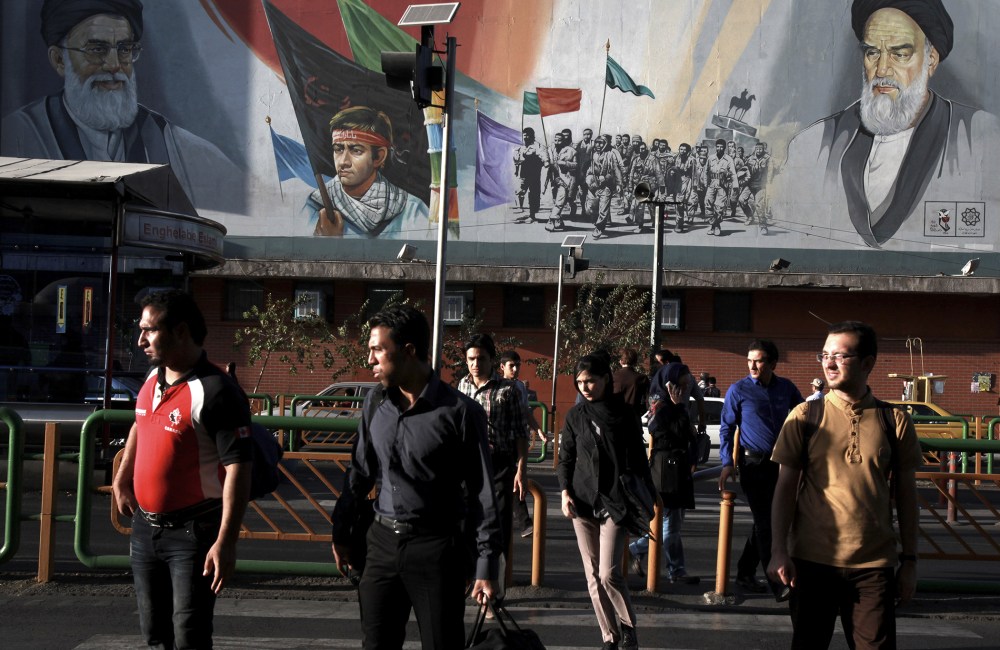 Pedestrians walk past a poster in Tehran depicting Iranian soldiers during the war with Iraq in the 1980s, on Sept. 25, 2013.