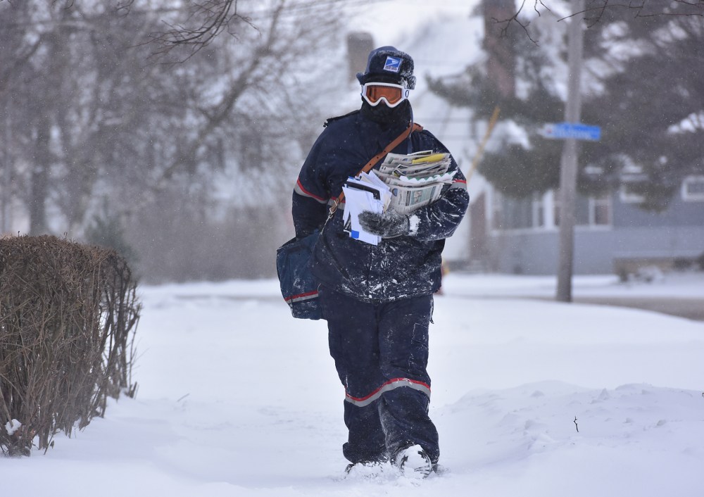 Jake Cote, a carrier with the United States Postal Service, delivers mail along Sunset Avenue, Feb. 11, 2016, in Utica, N.Y. (Photo by Mark DiOrio/Observer-Dispatch/AP)
