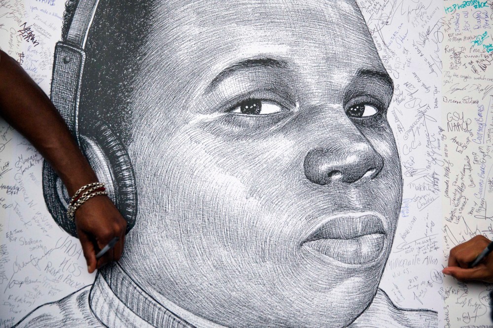 Protestors autograph a sketch of Michael Brown during a protest, Monday, Aug. 18, 2014, in Atlanta, Ga. (Photo by David Goldman/AP)