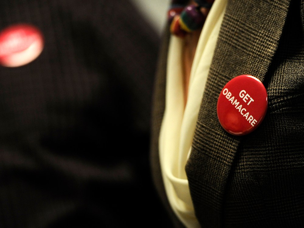 Associates at Community Health Center wear buttons reading "Get Obamacare" during a session to enroll people in the nation's new health insurance system at the Community Health Center, Tuesday, Oct. 1, 2013, in New Britain, Conn.