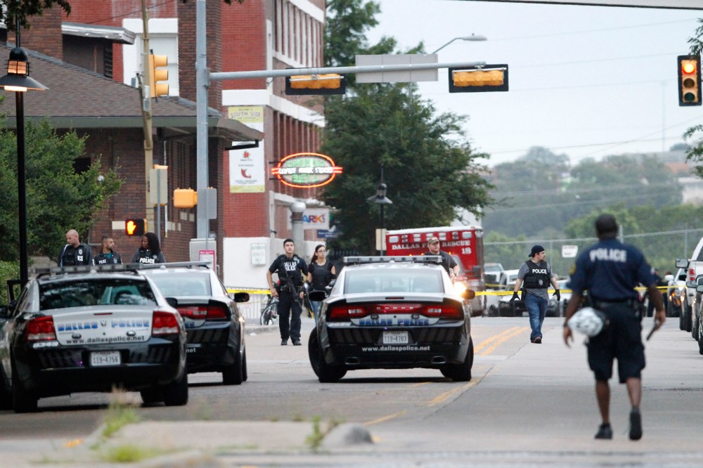 Dallas police officers walk down Belleview Street one block away from police headquarters searching the area on June 13, 2015, in Dallas, Texas. (Photo by Tony Gutierrez/AP)