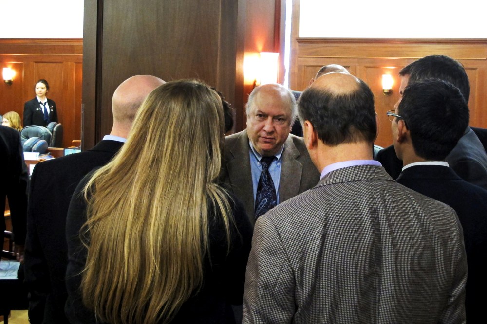 Max Gruenberg, D-Anchorage, huddles with fellow minority Democrats during a break in the floor debate on a minimum wage bill in Juneau, Alaska, April 13, 2014.