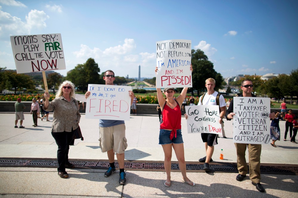 Protestors holds signs against the government shutdown on the West Front of the U.S. Capitol building on Capitol Hill on Friday, Oct. 4, 2013 in Washington.