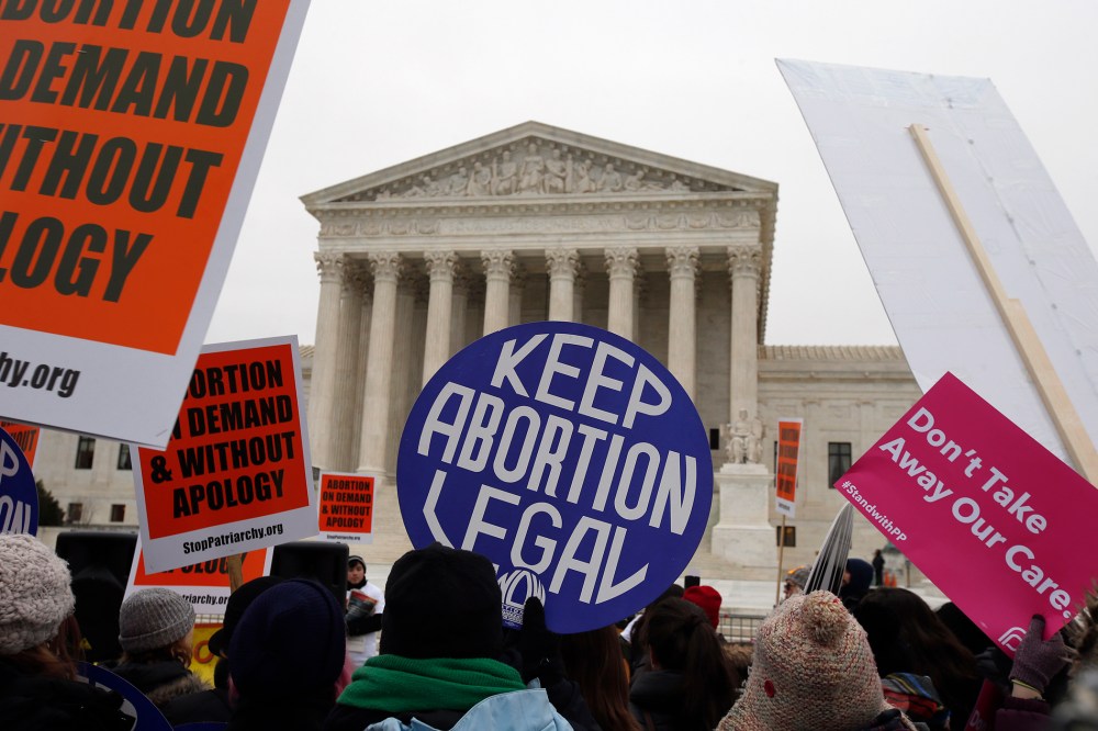 Pro-choice signs are seen during the March for Life 2016, in front of the U.S. Supreme Court, Jan. 22, 2016. (Photo by Alex Brandon/AP)