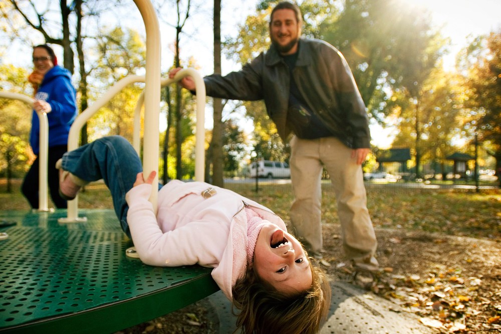A family plays at a playground at Overton Park in Memphis, Tenn.