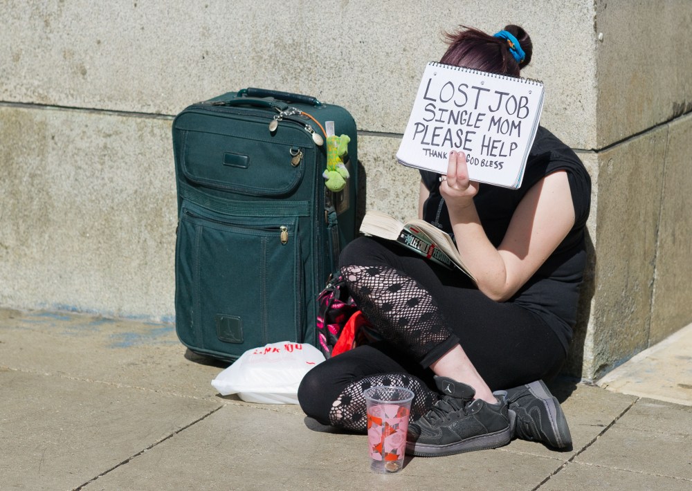 A woman in Chicago holding a sign that says: "Lost Job. Single Mom. Please Help." (Peer Grimm/picture-alliance/dpa/AP Images)
