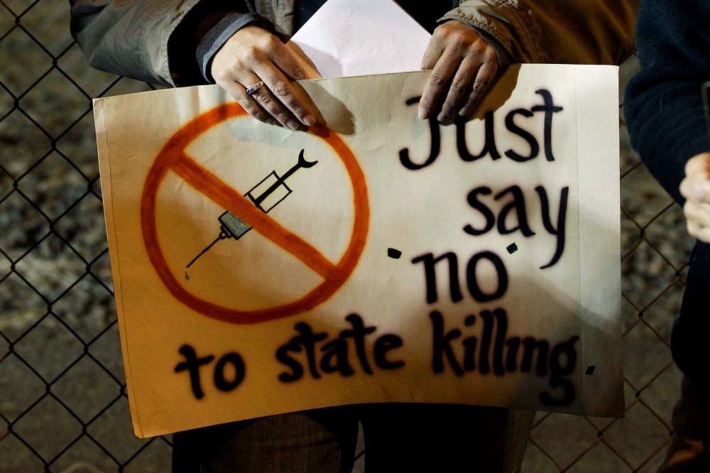 A woman holds a sign outside the Washington State Penitentiary, in Walla Walla, Wash, Sept. 9, 2010.