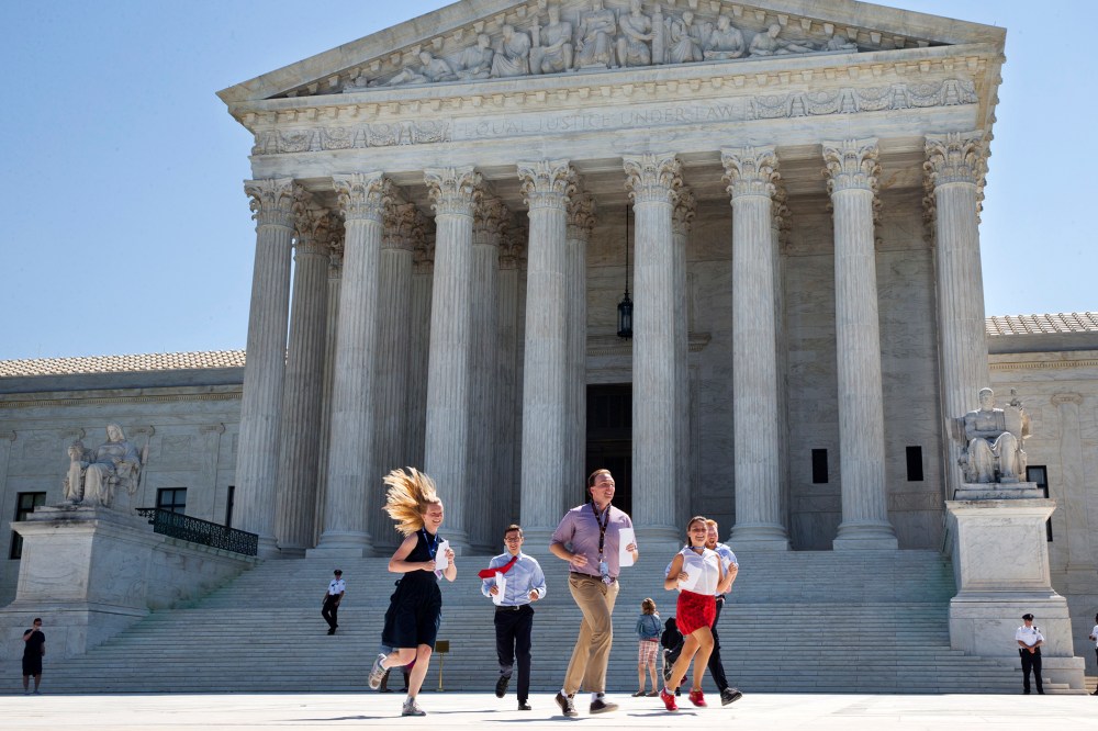 New interns run with a decision across the plaza of the Supreme Court in Washington, June 29, 2015. (Photo by Jacquelyn Martin/AP)