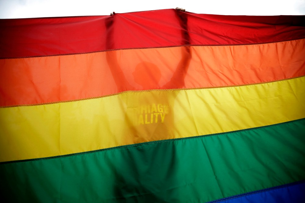 A gay marriage supporter holds up a flag during a rally for gay marriage, on June 26, 2013, on Independence Mall in Philadelphia.