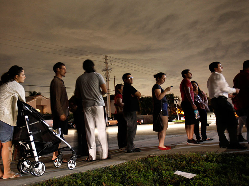 This Nov. 6, 2012 file photo shows voters lined up in the dark to beat the 7 p.m. deadline to cast their ballots at a polling station in Miami. (Photo by Wilfredo Lee/AP)