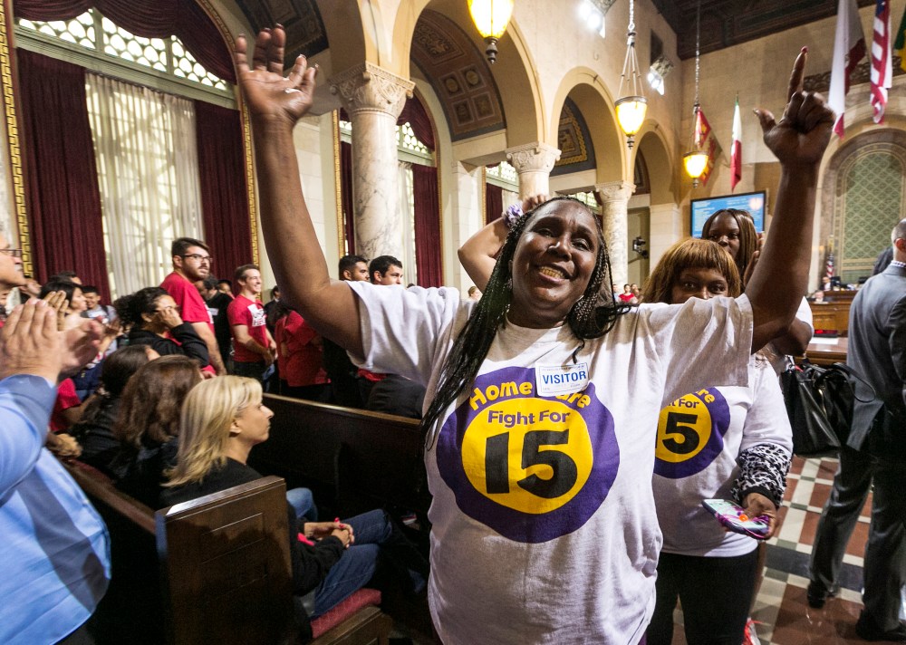 Workers react as the Los Angeles City Council votes 13-1 to raise the minimum wage to $15 an hour by 2020, but a second vote is required for final approval because the tally was not unanimous, in Los Angeles, June 3, 2015. (Photo by Damian Dovarganes/AP)