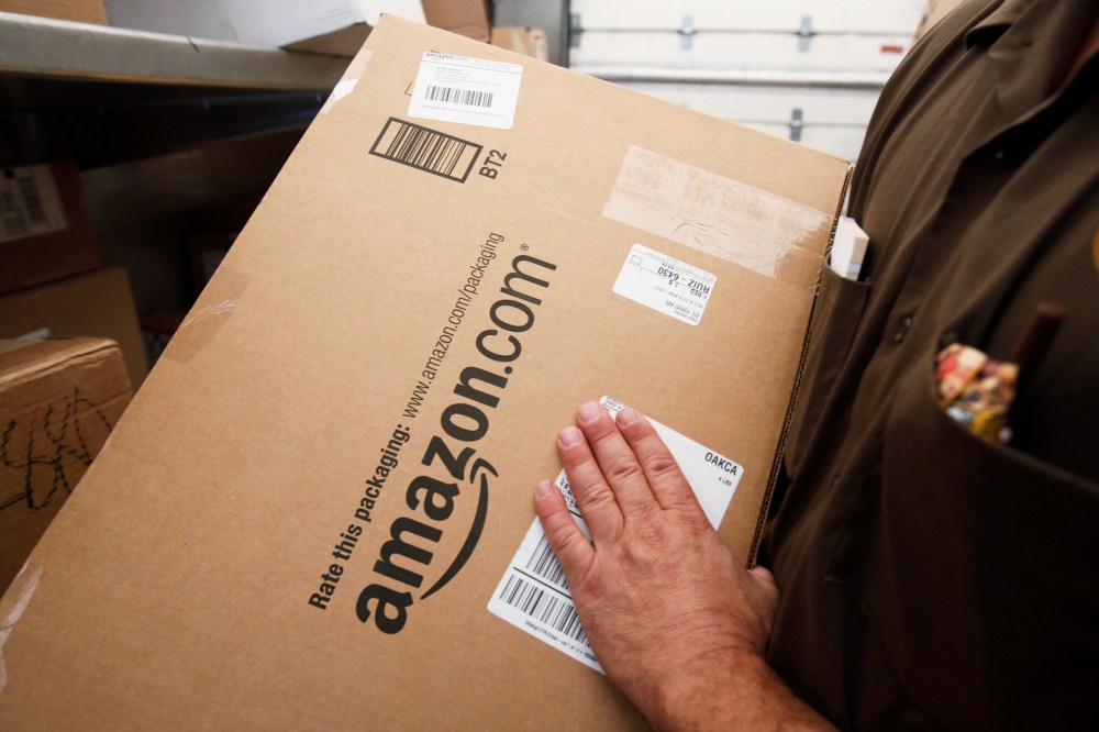 In this Oct. 18, 2010 file photo, United Parcel Service (UPS) driver delivers an Amazon box. (Photo by Paul Sakuma/AP)
