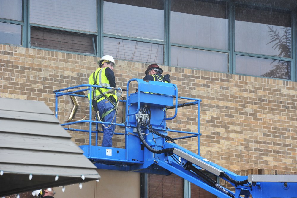 Workers remove the letters from the Sigma Alpha Epsilon house at the University of Oklahoma on March. 9, 2015, in Norman, Okla. (Photo by Nick Oxford/AP)