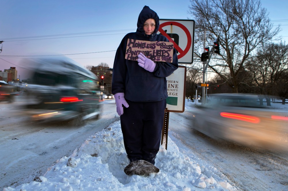 Victoria Morris, 28, panhandles in Portland, Maine, where the temperature at dusk was 7 degrees Fahrenheit, Jan. 3, 2014.