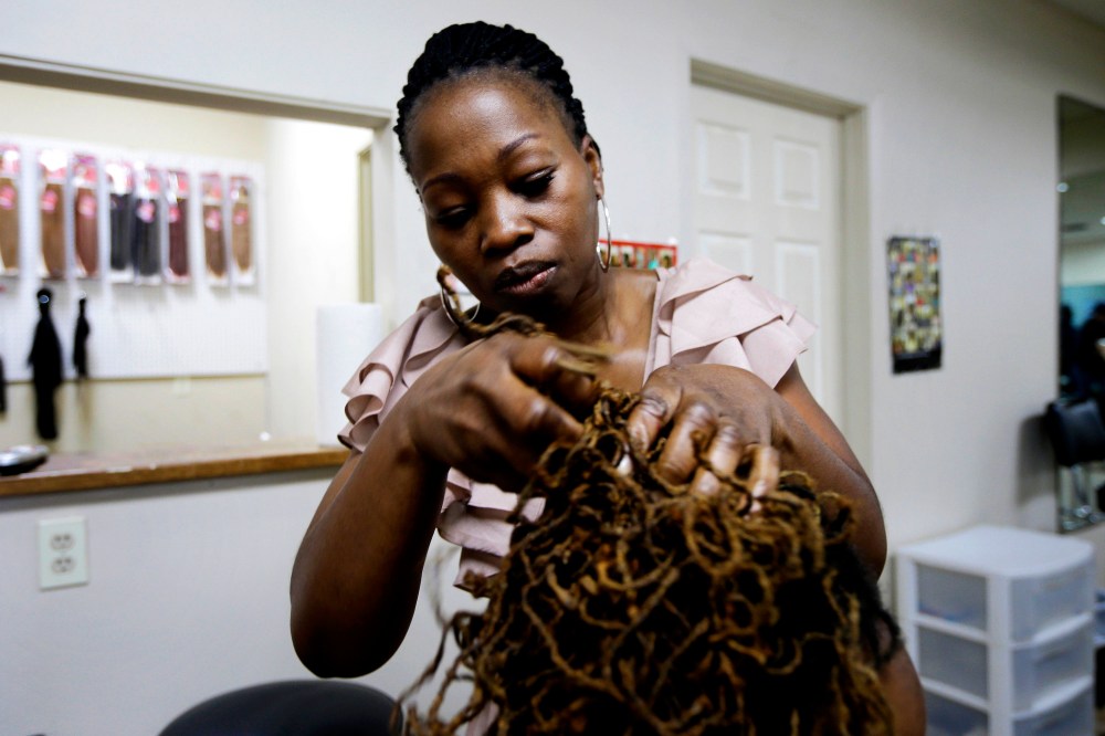 Christine McLean braids a client's hair at her shop in Ark., June 17, 2014 -- one of several states challenging state cosmetology licensing requirements as part of a legal campaign against increased government regulation. (AP Photo/Danny Johnston)