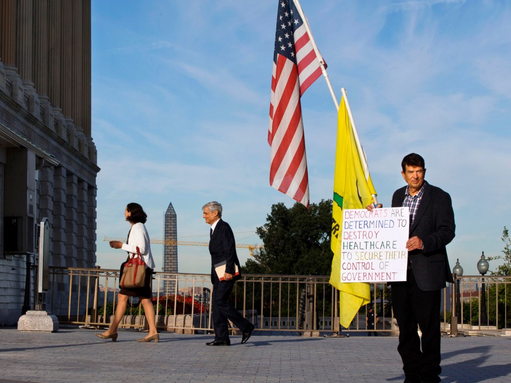 A member of the Tea Party holds a sign against Obamacare outside the Senate side of the Capitol in Washington, Wednesday, Sept. 25, 2013.