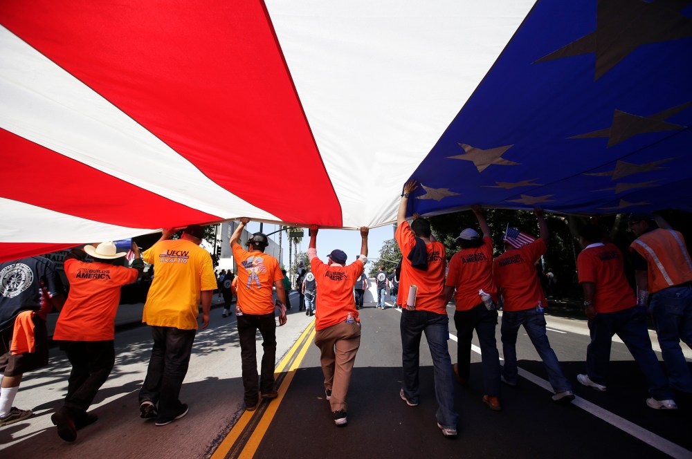 Union workers march along the street with a huge American flag during a May Day rally in Los Angeles, Calif., May 1, 2013.