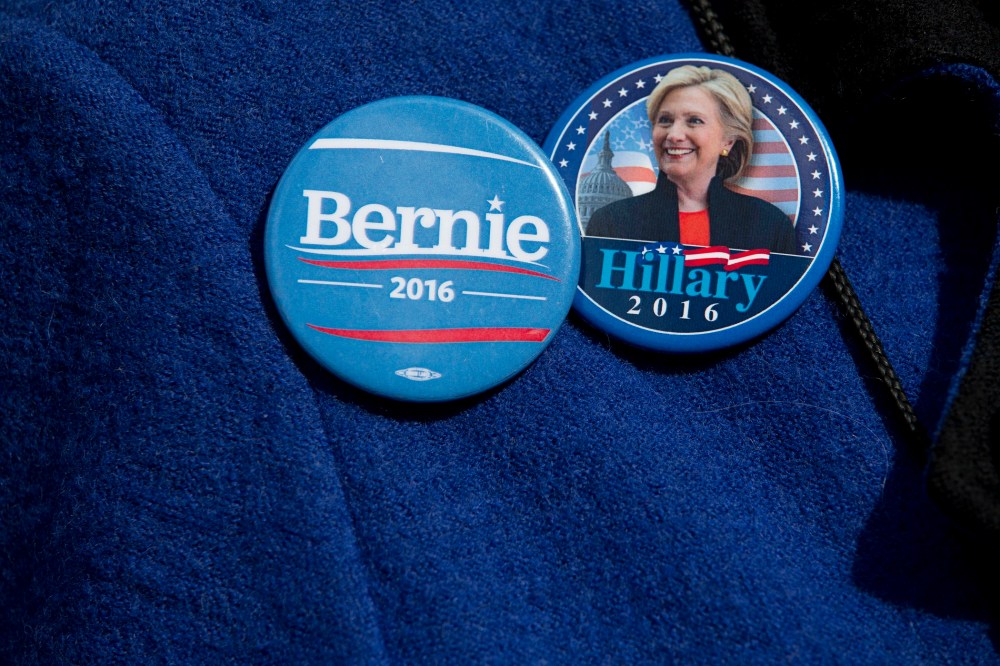 A voter wears buttons for Democratic presidential candidates Sen. Bernie Sanders, I-Vt., and Hillary Clinton buttons, March 31, 2016, in New York. (Photo by Mary Altaffer/AP)