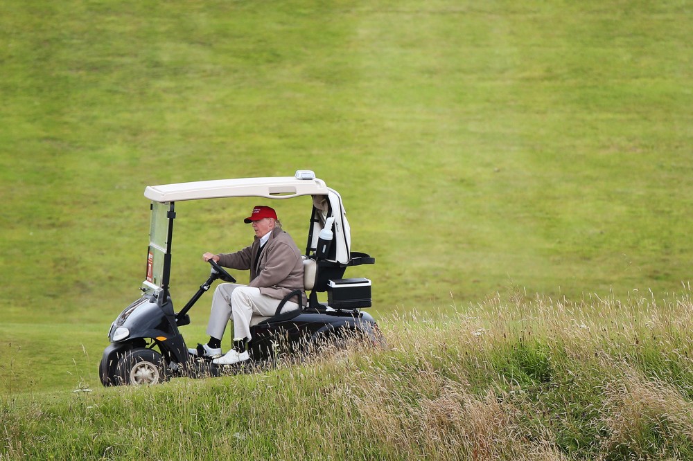 In this July 31, 2015 file photo, Republican presidential candidate Donald Trump drives his golf buggy on the Turnberry golf course in Turnberry, Scotland. (Photo by Scott Heppell/AP)