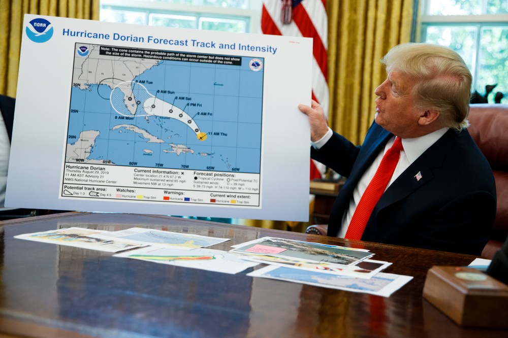 President Donald Trump holds a chart as he talks with reporters after receiving a briefing on Hurricane Dorian in the Oval Office of the White House, Wednesday, Sept. 4, 2019, in Washington.
