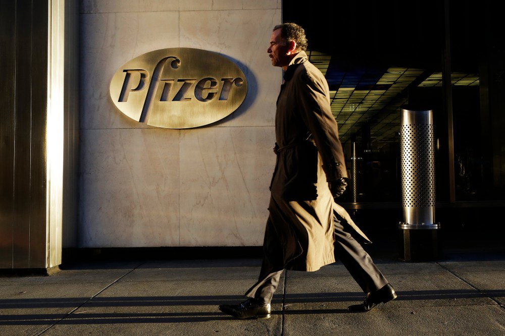 A man walks past Pfizer World Headquarters, Nov. 23, 2015 in New York. (Photo by Mark Lennihan/AP)