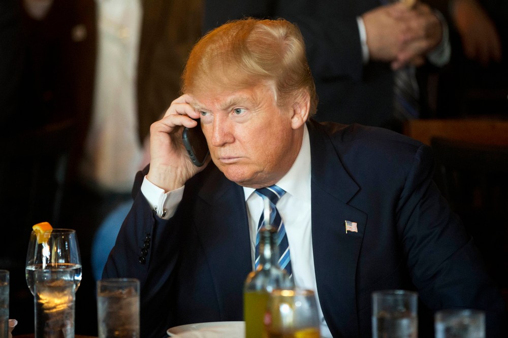 Republican presidential candidate Donald Trump listens to his mobile phone during a lunch stop, Feb. 18, 2016, in North Charleston, S.C. (Photo by Matt Rourke/AP)
