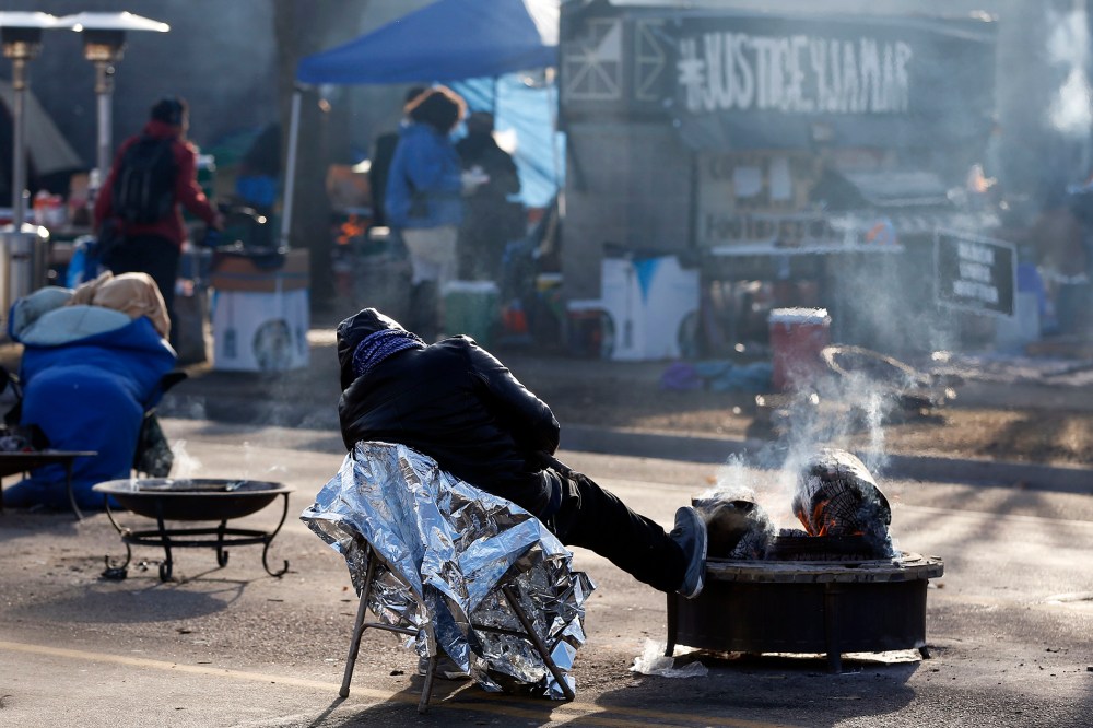 A protester gets some rest at the Black Lives Matter encampment, Tuesday, Nov. 24, 2015, outside the Minneapolis Police Department's Fourth Precinct in Minneapolis. (Photo by Jim Mone/AP)