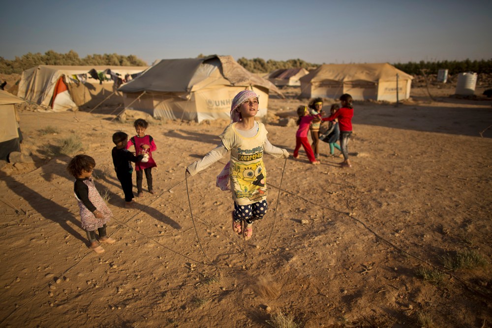 Syrian refugee girl, Zubaida Faisal, 10, skips a rope while she and other children play near their tents at an informal tented settlement near the Syrian border on the outskirts of Mafraq, Jordan, July 19, 2015. (Photo by Muhammed Muheisen/AP)
