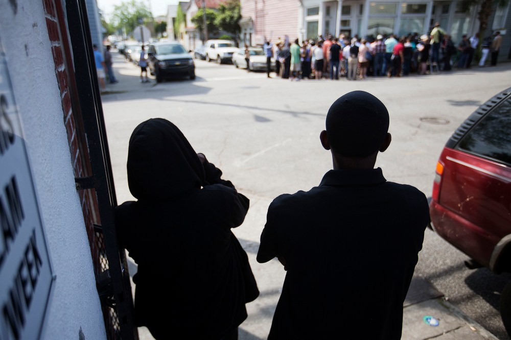 A couple watch from across the street during a news conference outside the Charleston NAACP office regarding the shooting death of Walter Scott by a North Charleston police officer, Thursday, April 9, 2015. (Photo by David Goldman/AP)