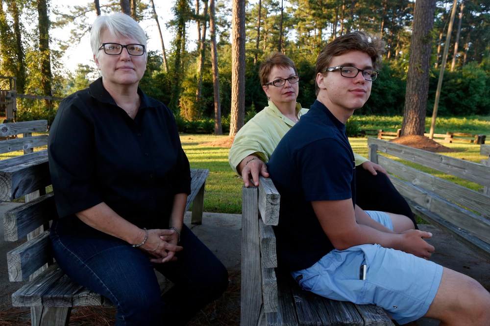 Hudson Garner, 15, right, sits outside with his mothers Kathryn Garner, and Susan Hrostowski, left, in Collins, Miss., Aug. 12, 2015. (Photo by Rogelio V. Solis/AP