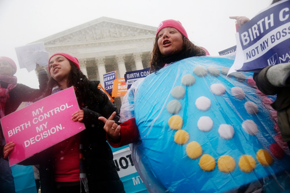 Citizens protest in front of the Supreme Court in Washington as the court heard oral arguments challenging a health care law's regulations regarding contraceptives, March 25, 2015. (Photo by Charles Dharapak/AP)