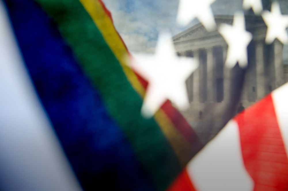 A rainbow colored flag, seen through an American flag, flies in front of the Supreme Court in Washington. (Photo by Andrew Harnik/AP)