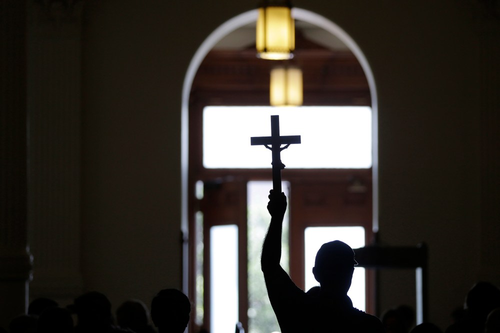 A man carries a cross. (Photo by Eric Gay/AP)