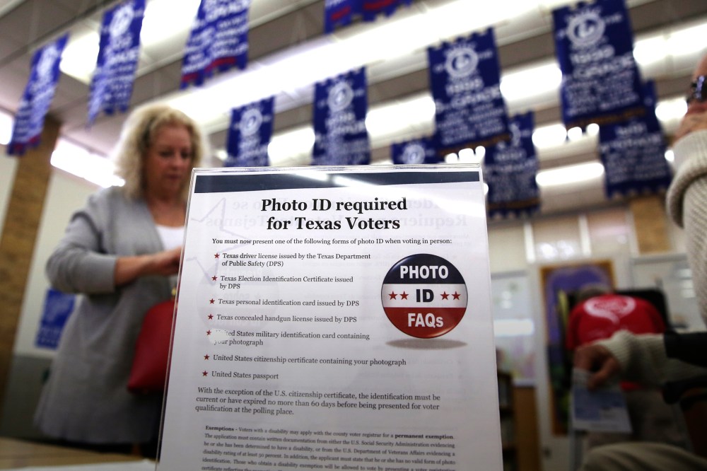 A sign tells voters of voter ID requirements before participating in the primary election at Sherrod Elementary school in Arlington, Texas, March 1, 2016. (Photo by LM Otero/AP)
