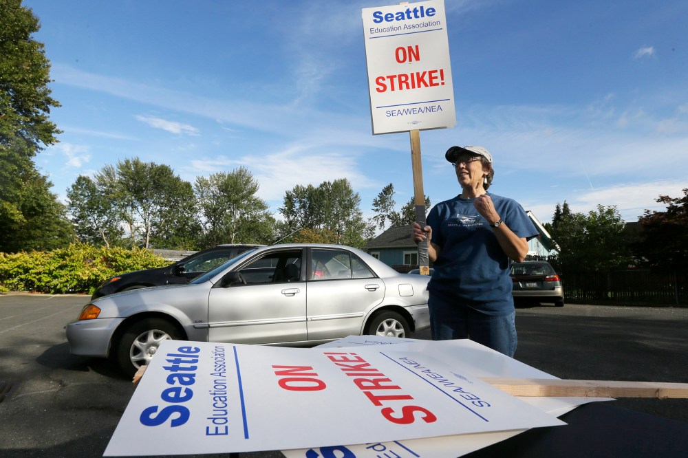 Nancy Kiser, a fifth-grade teacher at Kimball Elementary School, examines a picket sign to be used in the event of a strike by teachers in the Seattle School District on Sept. 8, 2015, in Seattle, Wash. (Photo by Ted S. Warren/AP)