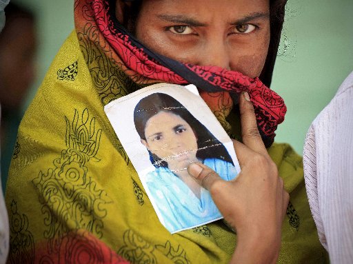 A woman holds a photo of her missing sister after a garment factory building collapsed last week in Savar near Dhaka, Bangladesh, Friday May 3, 2013. (AP Photo/Ismail Ferdous)