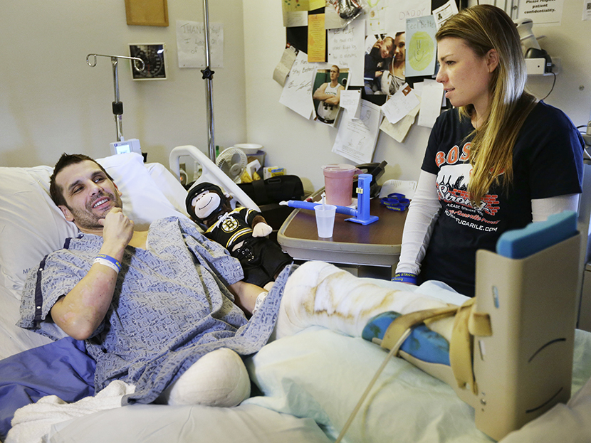 Marc Fucarile, left, speaks with members of the media as his fiancee, Jennifer Regan, right, looks on in his room at Massachusetts General Hospital in Boston on May 9, 2013.  (Photo by Steven Senne/AP)