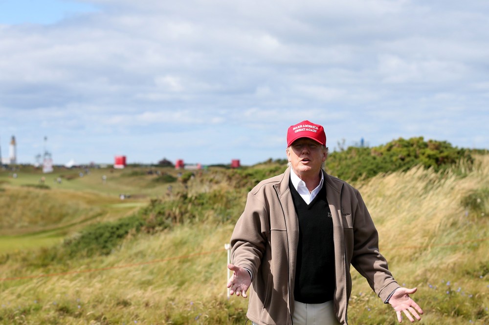 Presidential contender Donald Trump gestures to the media on the 17th fairway on the first day of the Women's British Open golf championship on the Turnberry golf course in Turnberry, Scotland, July 30, 2015. (Photo by Scott Heppell/AP)