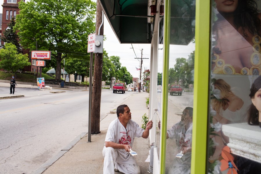 Fredy Garcia, 42, paints a building along Broad Street on May 26, 2014 in Central Falls, Rhode Island.