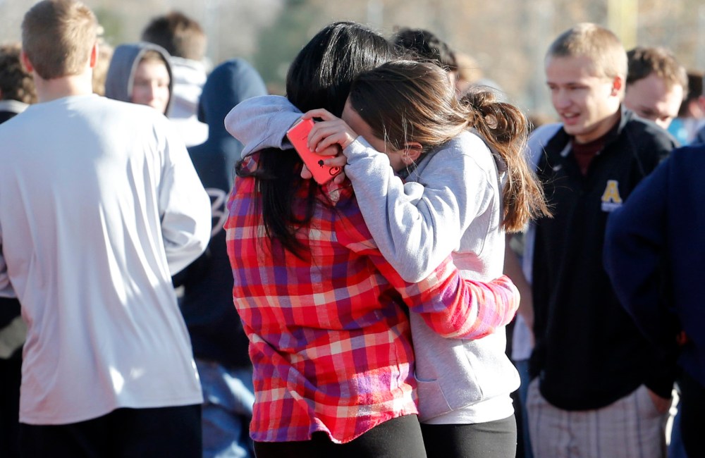 Students comfort each other outside of Arapahoe High School after a shooting on the campus in Centennial, Colo., on Friday, Dec. 13, 2013