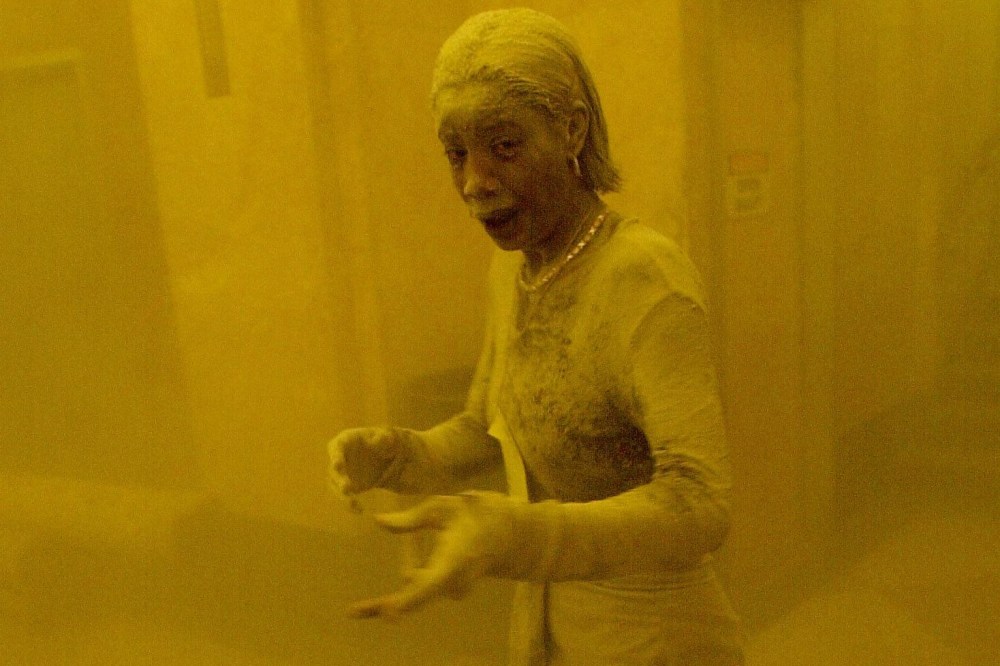 This Sept. 11, 2001 file photo shows Marcy Borders covered in dust as she takes refuge in an office building after one of the World Trade Center towers collapsed in New York. (Photo by Stan Honda/AFP/Getty)