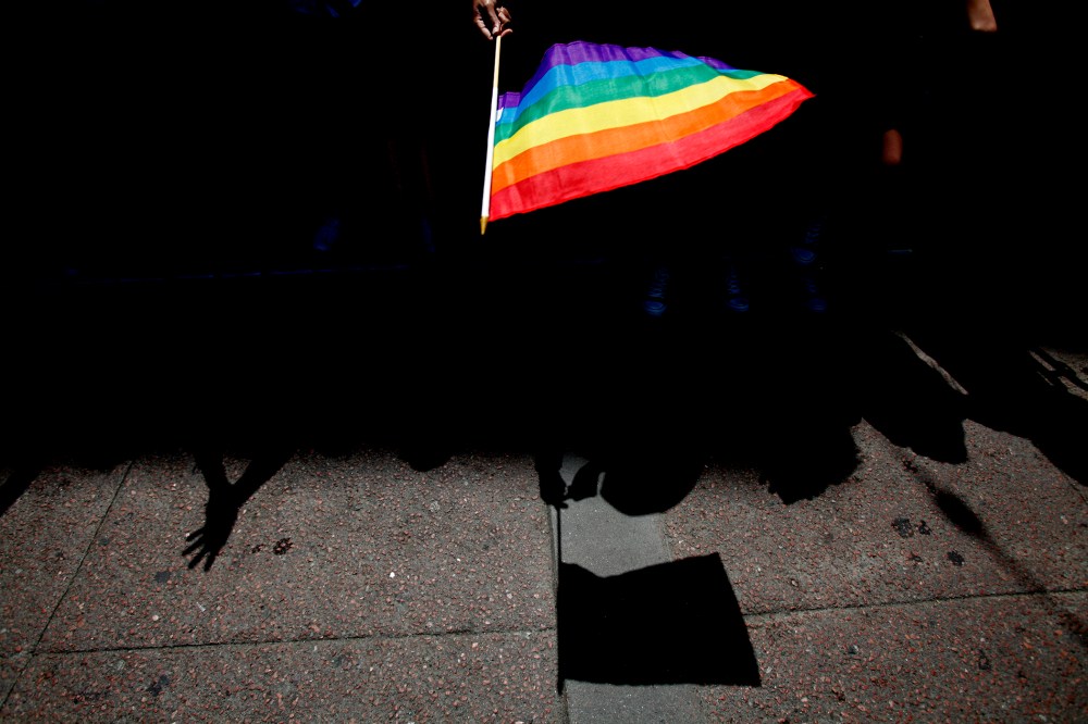 A parade goer waves a pride flag. (Photo by Sarah Rice/Getty)