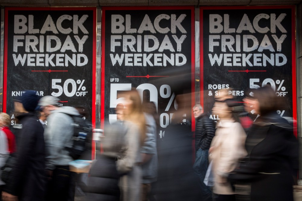 People walk past a shopfront advertising 'Black Friday' discounts on Nov. 28, 2014 in London, England. (Photo by Rob Stothard/Getty)