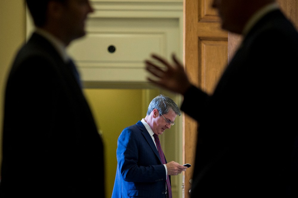 Sen. David Vitter, R-La., center, talks on his cell phone as two Senators in the foreground talk outside of the Senate Republicans' policy lunch in the Capitol on April 21, 2015 in Washington, D.C. (Photo By Bill Clark/CQ Roll Call/Getty)
