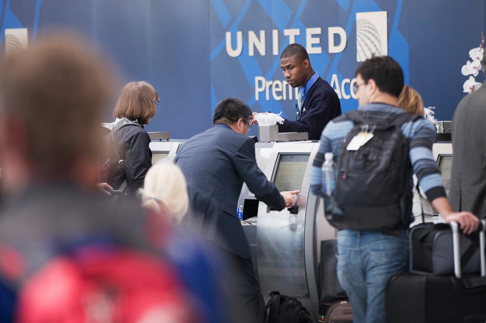 Passengers check-in for flights with United Airlines. (Photo by Scott Olson/Getty)