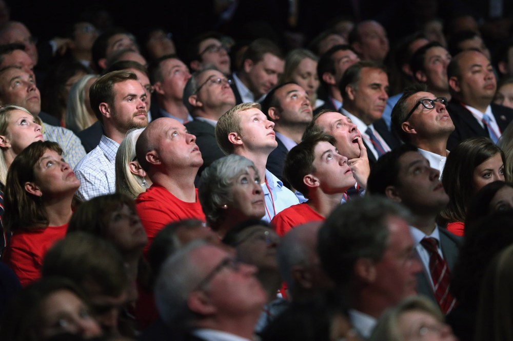 Audience members look up at the large video screen hanging above the first prime-time Republican presidential debate hosted by FOX News and Facebook at the Quicken Loans Arena on Aug. 6, 2015 in Cleveland, Ohio. (Photo by Chip Somodevilla/Getty)