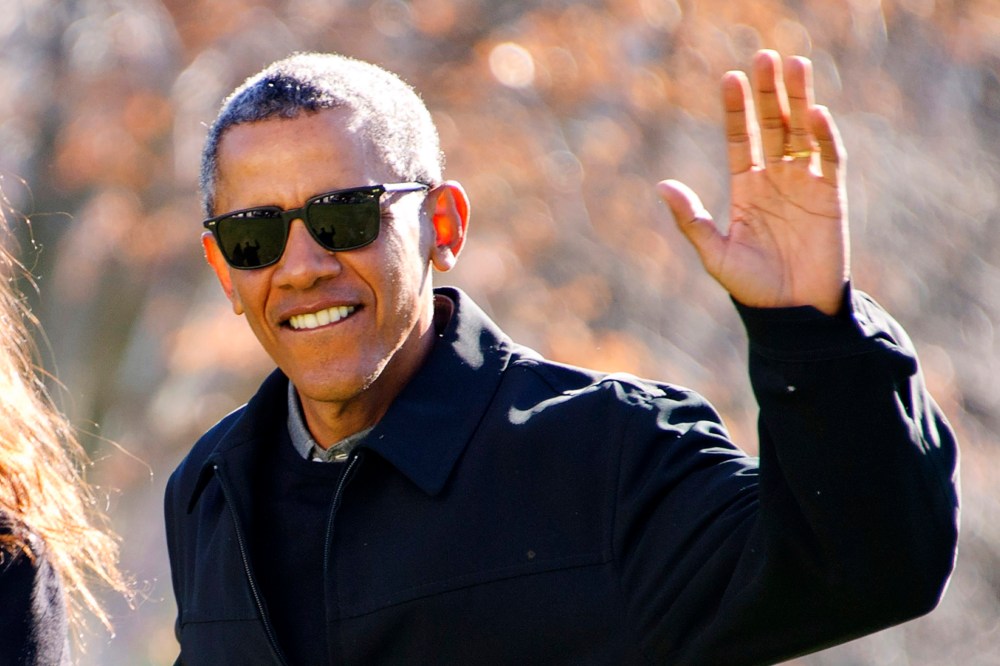 President Barack Obama waves to the press as he walks with his daughter Malia on his family's return to the South Lawn of the White House Jan. 3, 2016 in Washington, DC. (Photo by Ron Sachs/Pool/Getty)