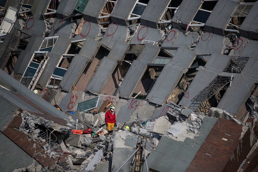 Rescue worker search for victim at a collapsed building on Feb. 7, 2016 in Tainan, Taiwan. A magnitude 6.4 earthquake hit southern Taiwan early Saturday, killing at least fourteen people, and leaving over one hundred missing. (Photo by Lam Yik Fei/Getty)