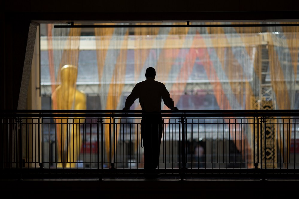 A security guard watches over operations near the primary Oscar statue as preparations are made for the 88th Annual Academy Awards at Hollywood & Highland Center on Feb. 24, 2016 in Hollywood, Calif. (Photo by David McNew/Getty)